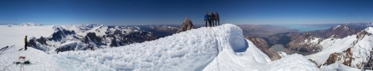 Tim on the left, the Brits on the summit of Cerro Torre. Fitz Roy and the Pampa in the back