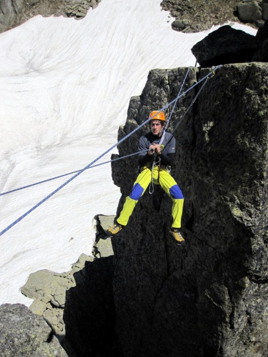 Friedemann hangt vol enthousiasme in de Tyrolienne tussen de Petit clochetons ©Jeroen