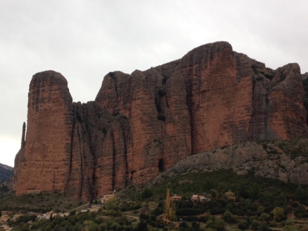 Mallos de Riglos, met het dorpje links onderaan in beeld, en de twee meest prominente wanden (links de Pison-toren en rechts de overhangende Visera-wand) © Denis